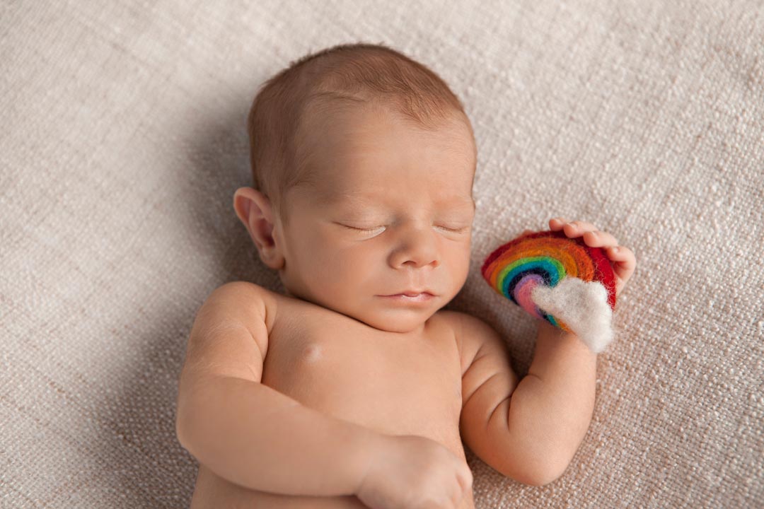 Newborn holding a Felt Rainbow Newborn Photography Melbourne