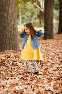 Girl laughing amounst Autumn Leaves