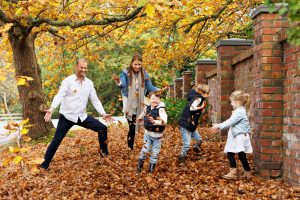 family playing in leaves
