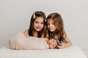 Newborn with two big sisters
