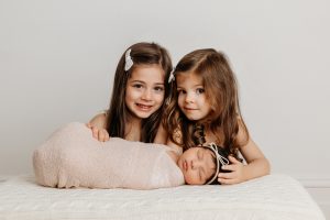 Newborn with two big sisters