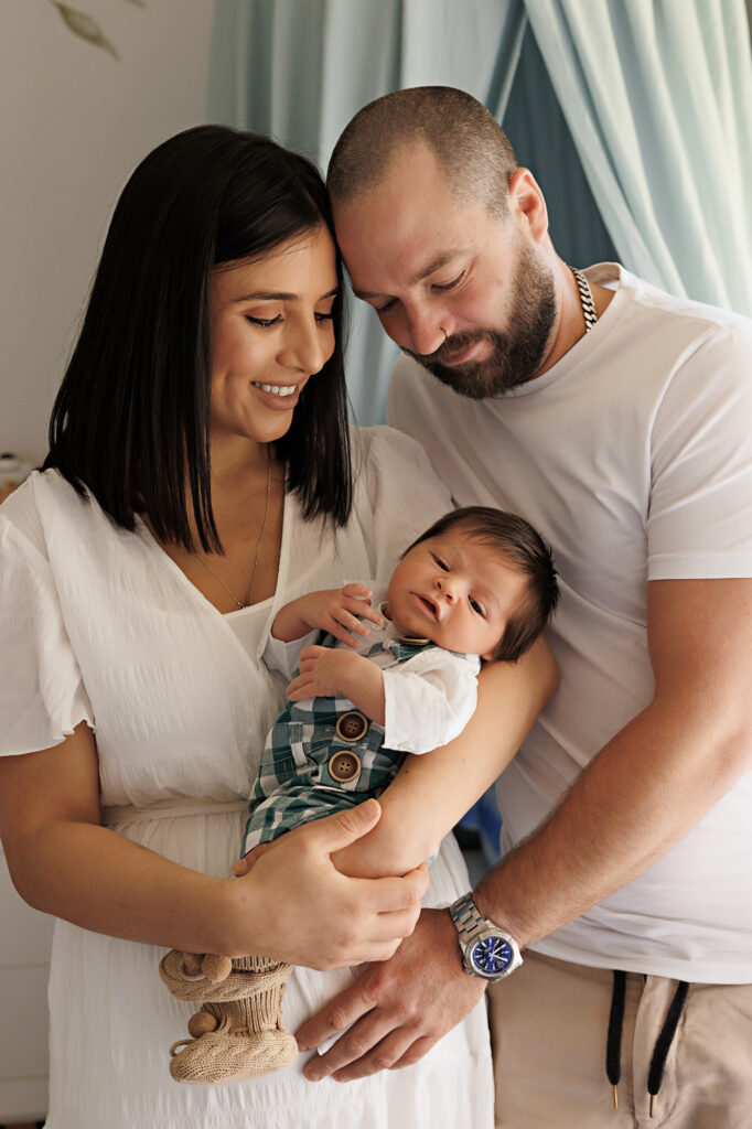A heartwarming moment: Family cherishing their newborn in the cozy ambiance of the baby's nursery.